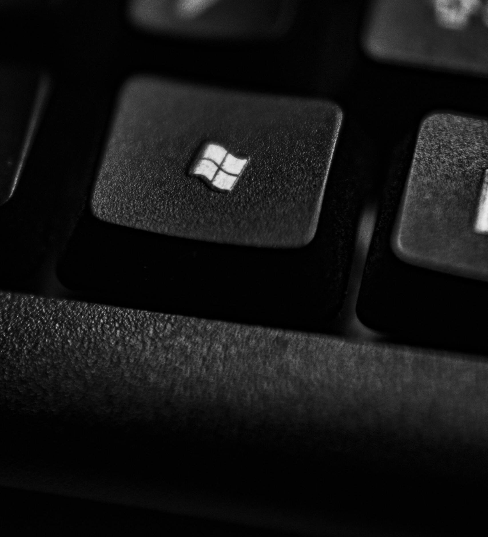 High-quality close-up of a Windows logo key on a black plastic keyboard.